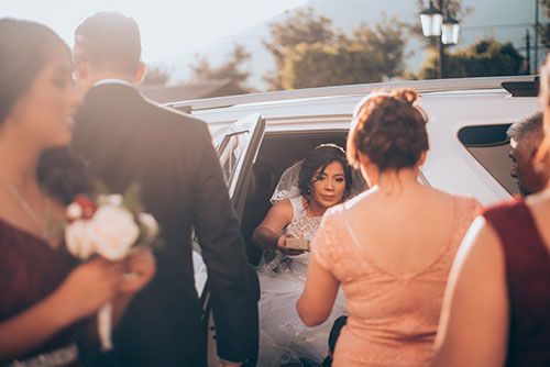 lady rides in a limo at her wedding day
